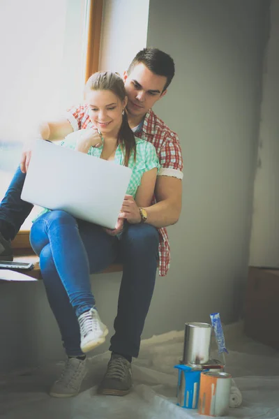 Casal em movimento em casa sentado no peitoril da janela com laptop — Fotografia de Stock