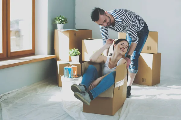 Szczęśliwa młoda para rozpakowaniu lub opakowania pudełka i Przeprowadzka do nowego domu — Zdjęcie stockowe