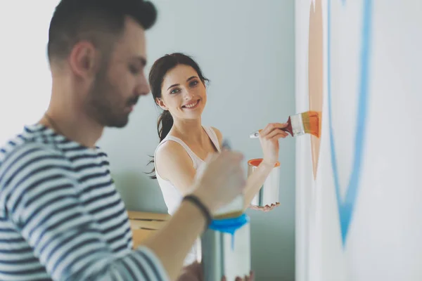 Portrait happy smiling young couple painting interior wall of new house — Stock Photo, Image