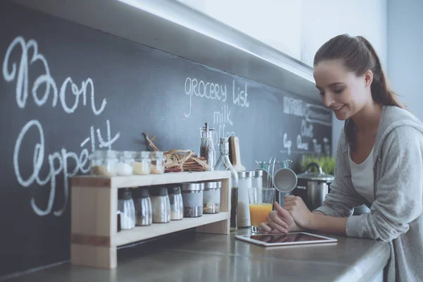 Frau backt zu Hause nach Rezept auf dem Tablet — Stockfoto