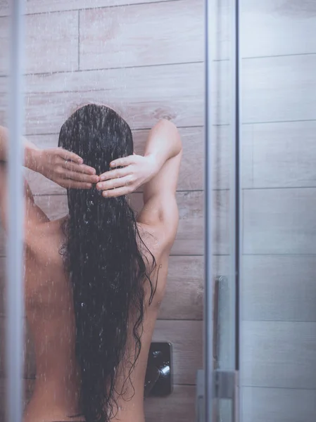 Jeune femme belle sous la douche dans la salle de bain — Photo