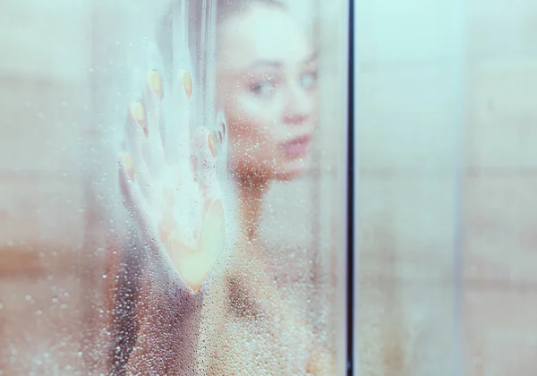 Junge schöne Frau unter der Dusche im Badezimmer — Stockfoto