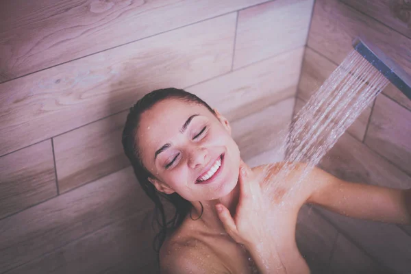 Jeune femme belle sous la douche dans la salle de bain — Photo