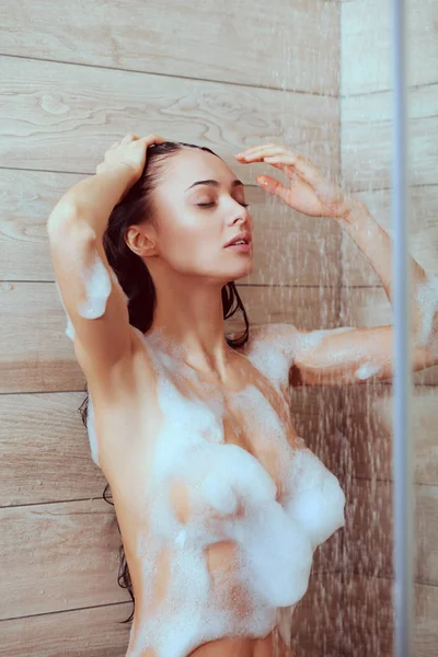 Young beautyful woman under shower in bathroom — Stock Photo, Image