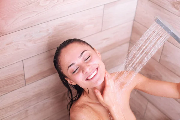 Junge schöne Frau unter der Dusche im Badezimmer — Stockfoto