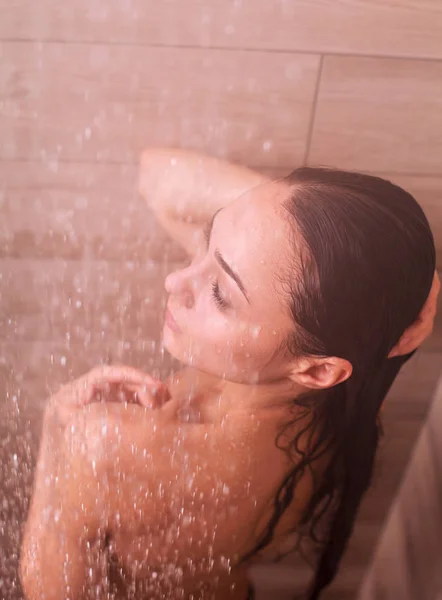 Молода жінка під душем у ванній — стокове фото