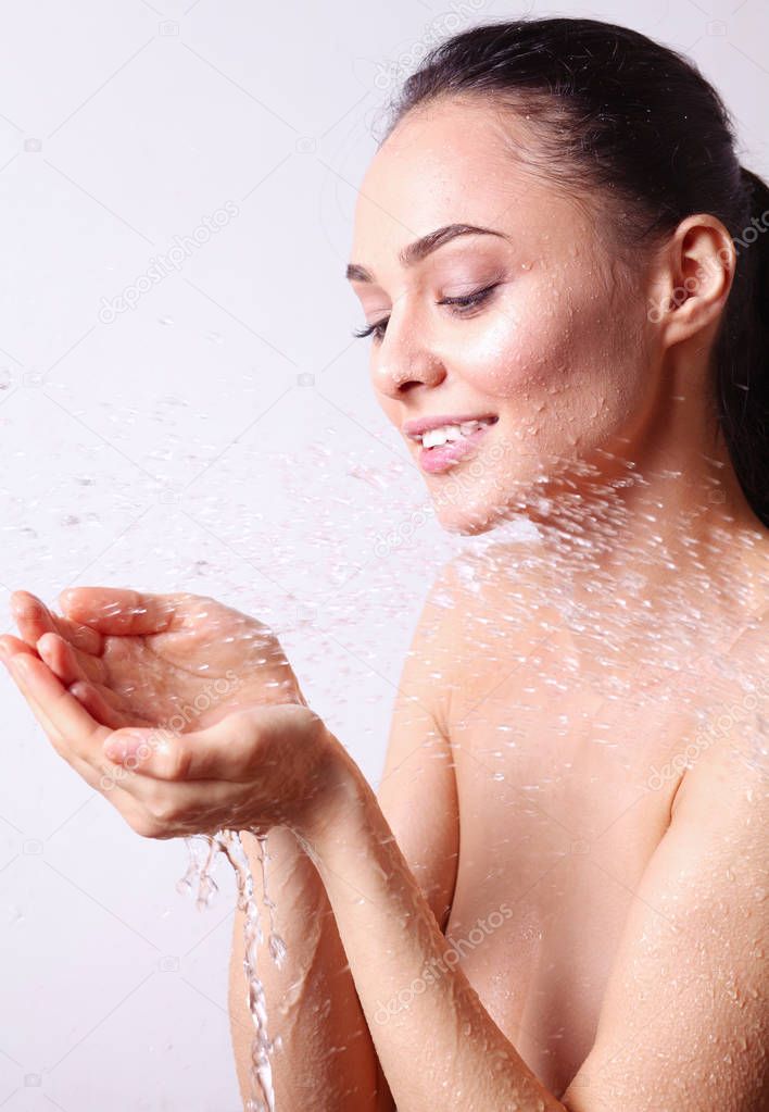 Young beautyful woman under shower in bathroom