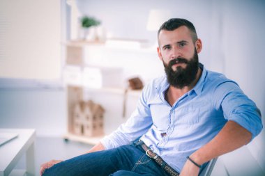 Genç işadamı koltukta oturuyor.