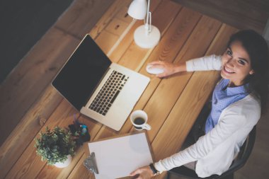 Masada oturan genç bir kadın.