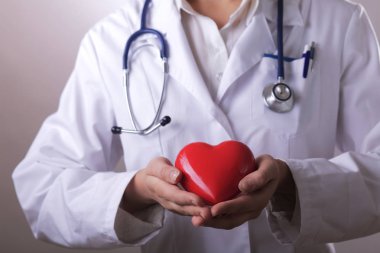 Kalp, koyu arka plan üzerinde tutarak stetoskop ile kadın doktor