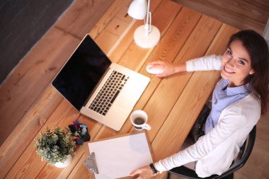 Masada oturan genç bir kadın.