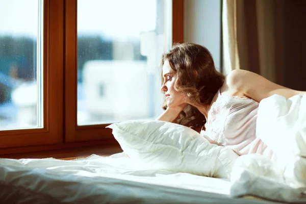 Bella donna sdraiata sul suo letto a casa — Foto Stock