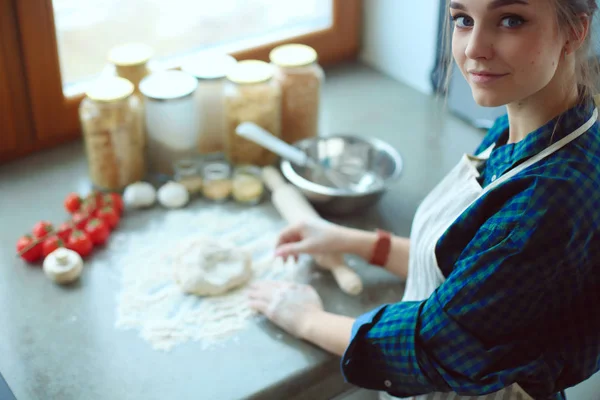 Belle femme cuisine gâteau dans la cuisine debout près du bureau — Photo