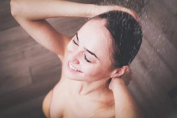 Молодая красивая женщина под душем в ванной комнате — стоковое фото
