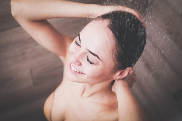 Joven mujer hermosa bajo la ducha en el baño — Foto de Stock