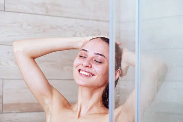 Joven mujer hermosa bajo la ducha en el baño — Foto de Stock