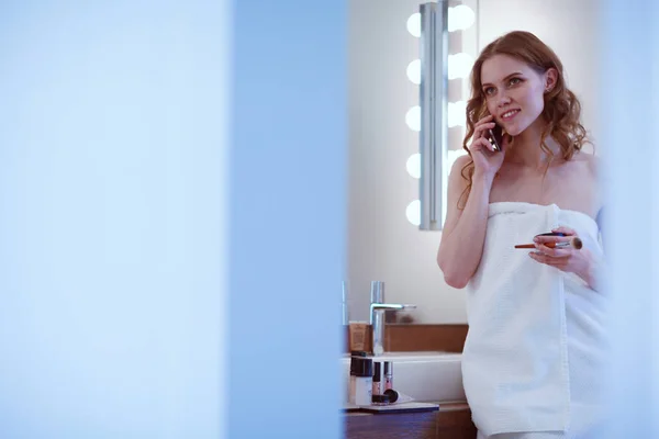 Fiatal nő állt a fürdőszoba, telefon — Stock Fotó