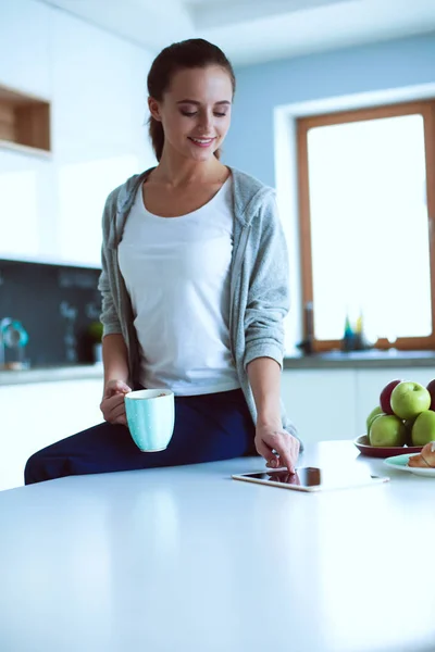 Lycklig kvinna dricka te i köket hemma — Stockfoto