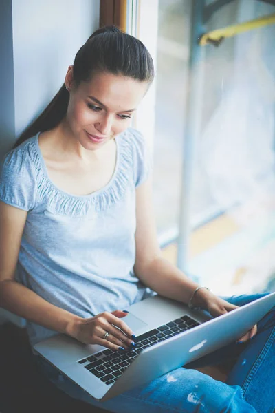 Ung vacker kvinna med hjälp av en bärbar dator hemma — Stockfoto