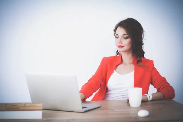 Mulher atraente sentada na mesa no escritório, trabalhando com computador portátil — Fotografia de Stock
