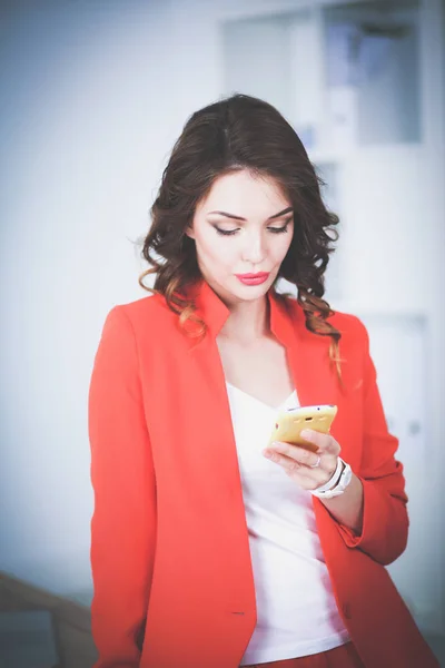 Güzel iş kadını ayakta cep telefonu kullanma office — Stok fotoğraf