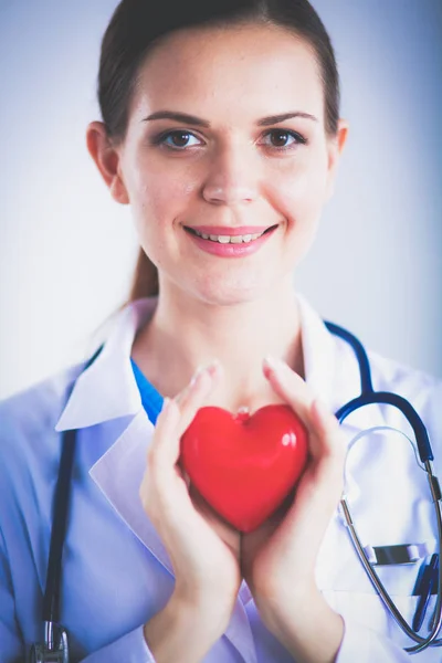 Jeune femme médecin tenant un cœur rouge — Photo