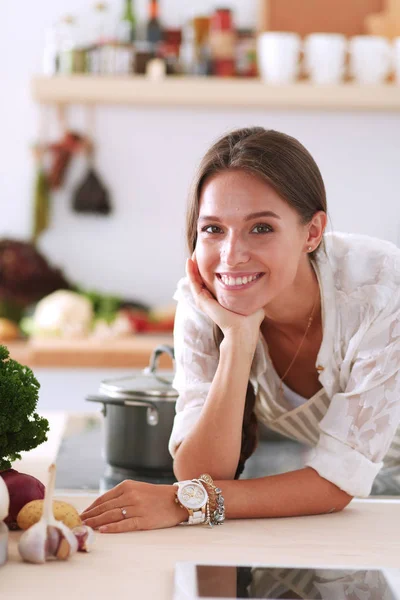 Jonge vrouw in de buurt van bureau in de keuken — Stockfoto