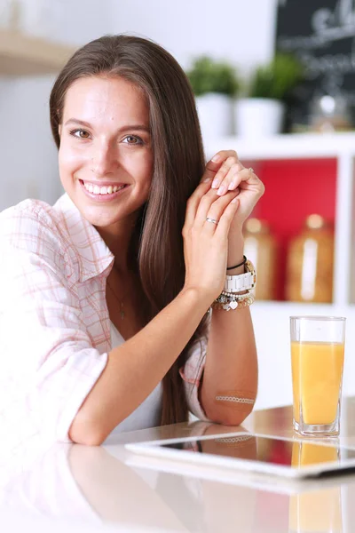 Junge Frau steht neben Schreibtisch in der Küche — Stockfoto