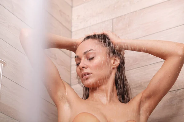 Jonge beautyful vrouw onder de douche in de badkamer — Stockfoto