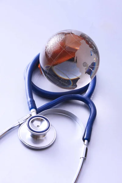 Globalnej opieki zdrowotnej. Globus i stetoskop, zdjęcia studyjne, niebieskie stonowane obrazy — Zdjęcie stockowe