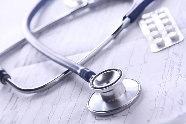 Medical stethoscope on electrocardiogram on desk — Stock Photo, Image