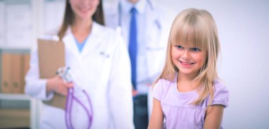 Kadın doktor ameliyatta steteskopla çocuğu muayene ediyor.