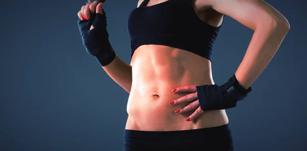 Muscular jovem mulher de pé sobre fundo cinza . — Fotografia de Stock