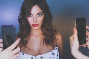Mükemmel yüz selfie smartphone ile stüdyoda alarak Kırmızı elbiseli güzel kadın