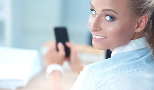Bizneswoman wysyłanie wiadomości ze smartfonem siedzi w biurze — Zdjęcie stockowe