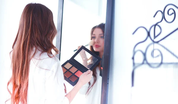 Young beautiful woman making make-up near mirror — Stock Photo, Image