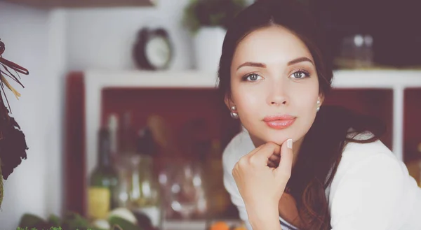 Jonge vrouw in de buurt van bureau in de keuken — Stockfoto