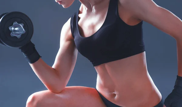 Athletic woman pumping up muscules with dumbbells — Stock Photo, Image