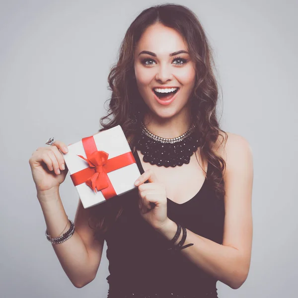 Mujer joven sonrisa feliz celebrar caja de regalo en las manos, aislado sobre fondo gris —  Fotos de Stock