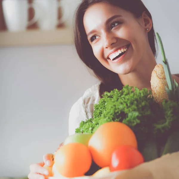 Young woman holding grocery shopping bag with vegetables — Stock Photo, Image