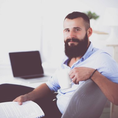 Genç işadamı koltukta oturuyor.