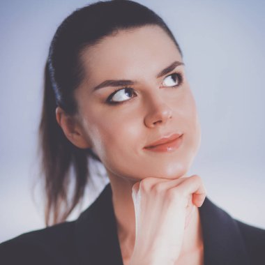 ayakta, gri arka plan üzerinde izole genç kadın