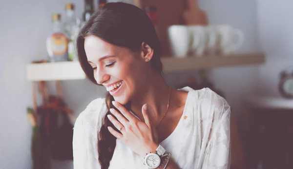 Young woman standing near desk in the kitchen — Stock Photo, Image