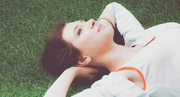 Schöne junge Frau auf grünem Gras liegend — Stockfoto