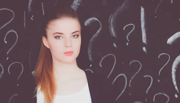 Jong meisje met vraagteken op een grijze achtergrond — Stockfoto