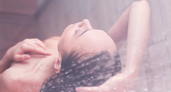 Junge schöne Frau unter der Dusche im Badezimmer — Stockfoto