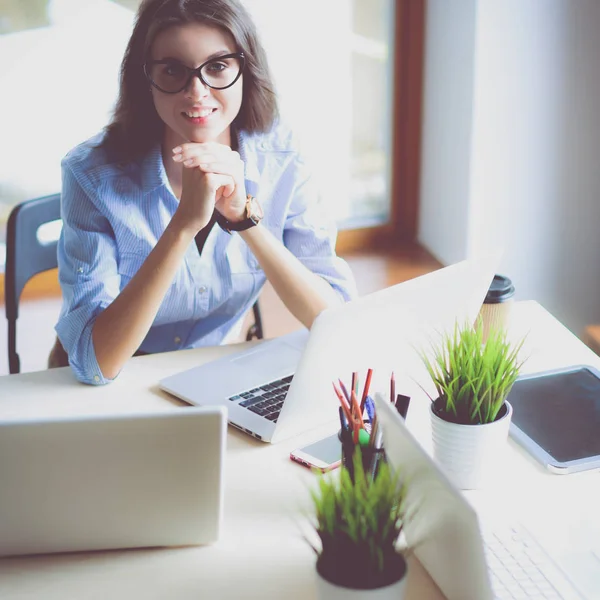 Jovem mulher sentada à mesa do escritório com laptop — Fotografia de Stock