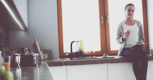 Красивая молодая женщина с помощью цифрового стола на кухне — стоковое фото