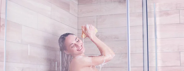 Jeune femme belle sous la douche dans la salle de bain — Photo