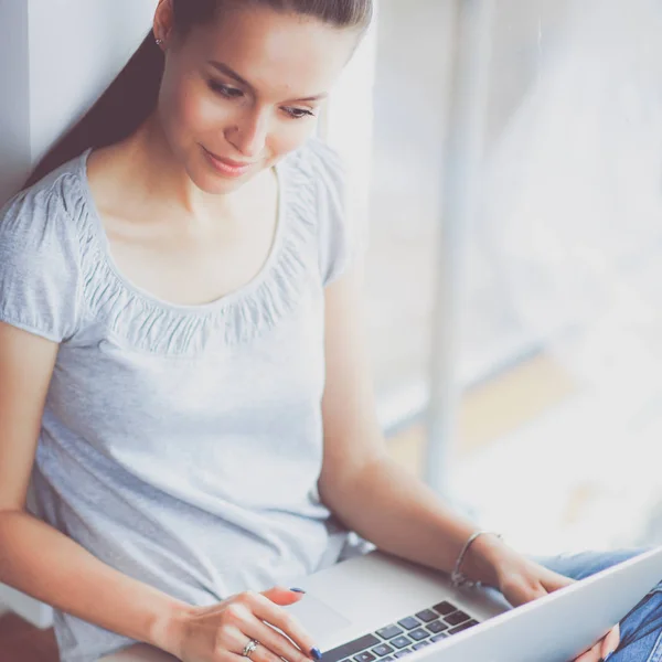 Unga vackra kvinnan hemma sitter på golvet med laptop — Stockfoto